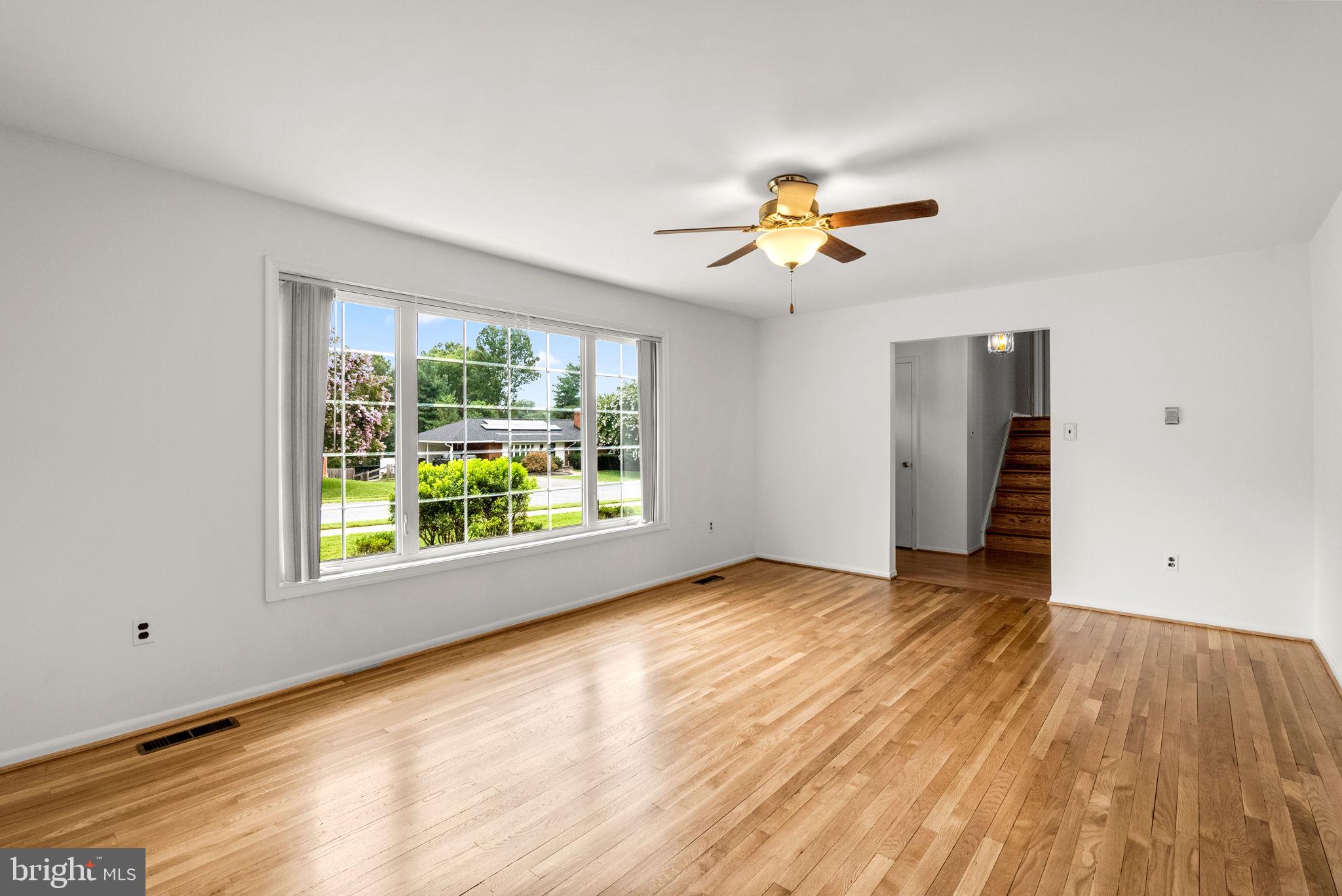 18724 Bloomfield Road Olney, MD 20832 - Photo 3 of 32 a view of empty room with wooden floor and fan