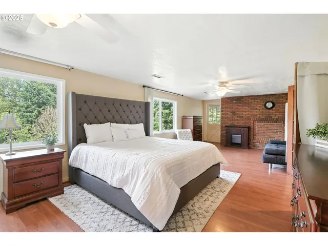 a bedroom with a bed a dresser next to a window