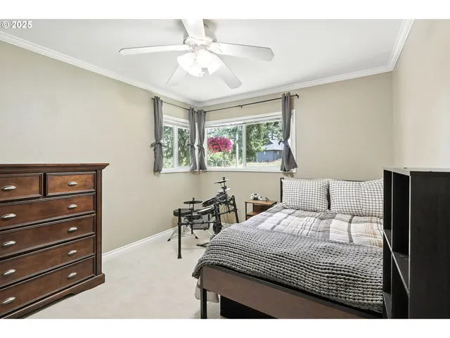 a bedroom with a bed a dresser and a chandelier