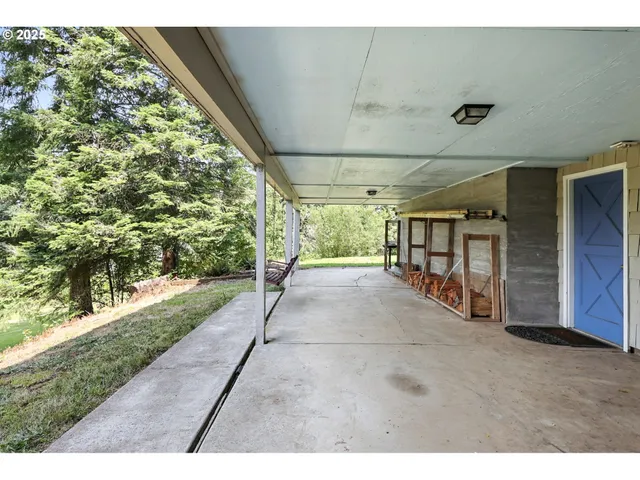 a backyard of a house with trees and outdoor seating