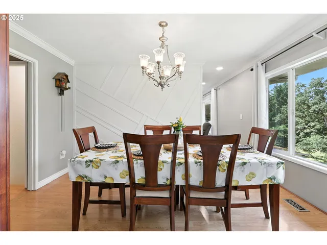 a view of a dining room with furniture a chandelier and wooden floor