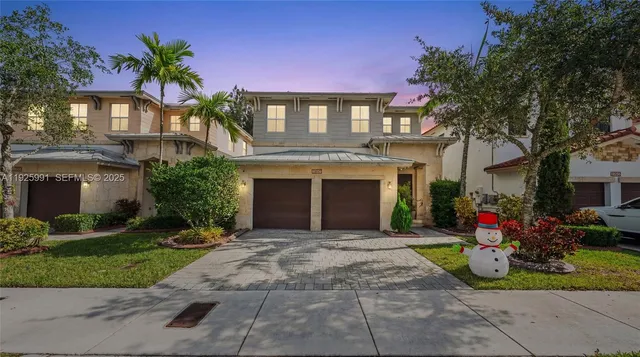 a front view of a house with a yard and potted plants