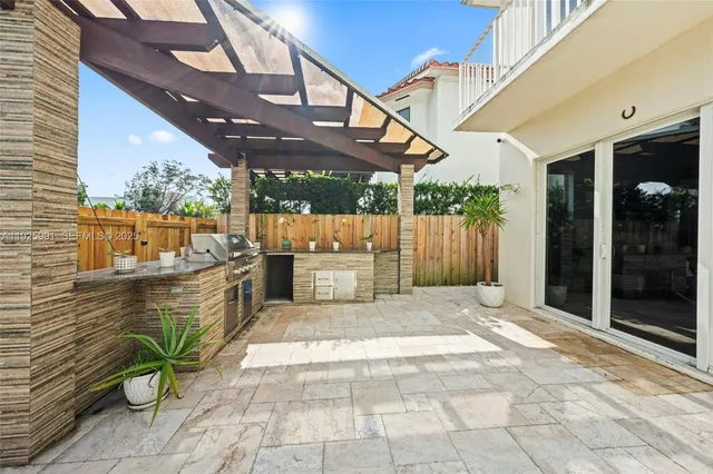 a kitchen with kitchen island a sink stainless steel appliances cabinets and a window