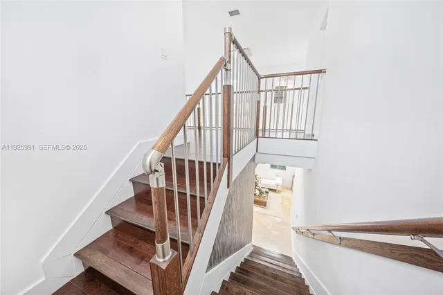 a view of a hallway with wooden floor and entryway