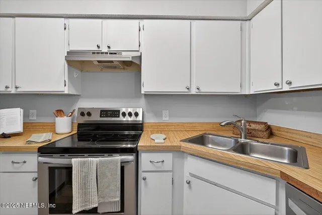 a kitchen with stainless steel appliances granite countertop a sink refrigerator and cabinets