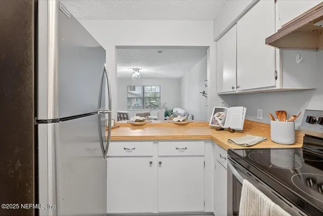 a kitchen with stainless steel appliances granite countertop a sink and a white cabinets