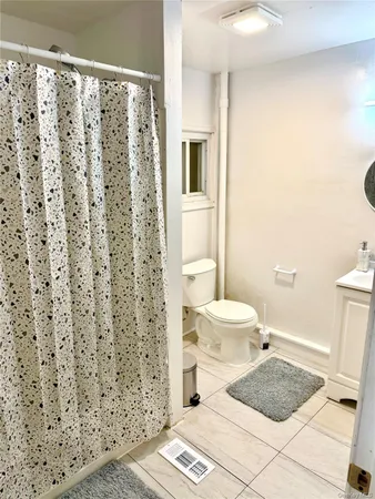 a bathroom with a granite countertop toilet and a shower