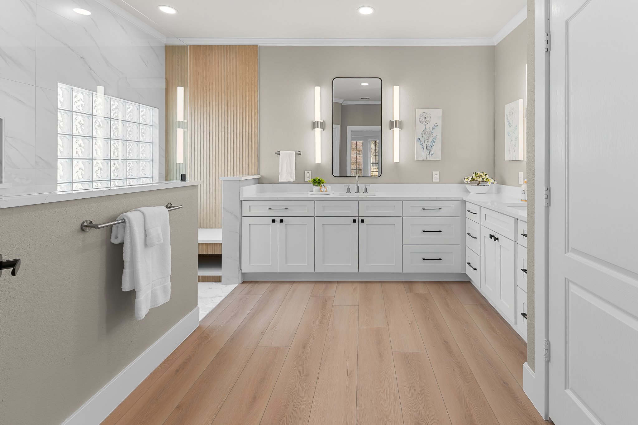 a spacious bathroom with double vanity and a mirror