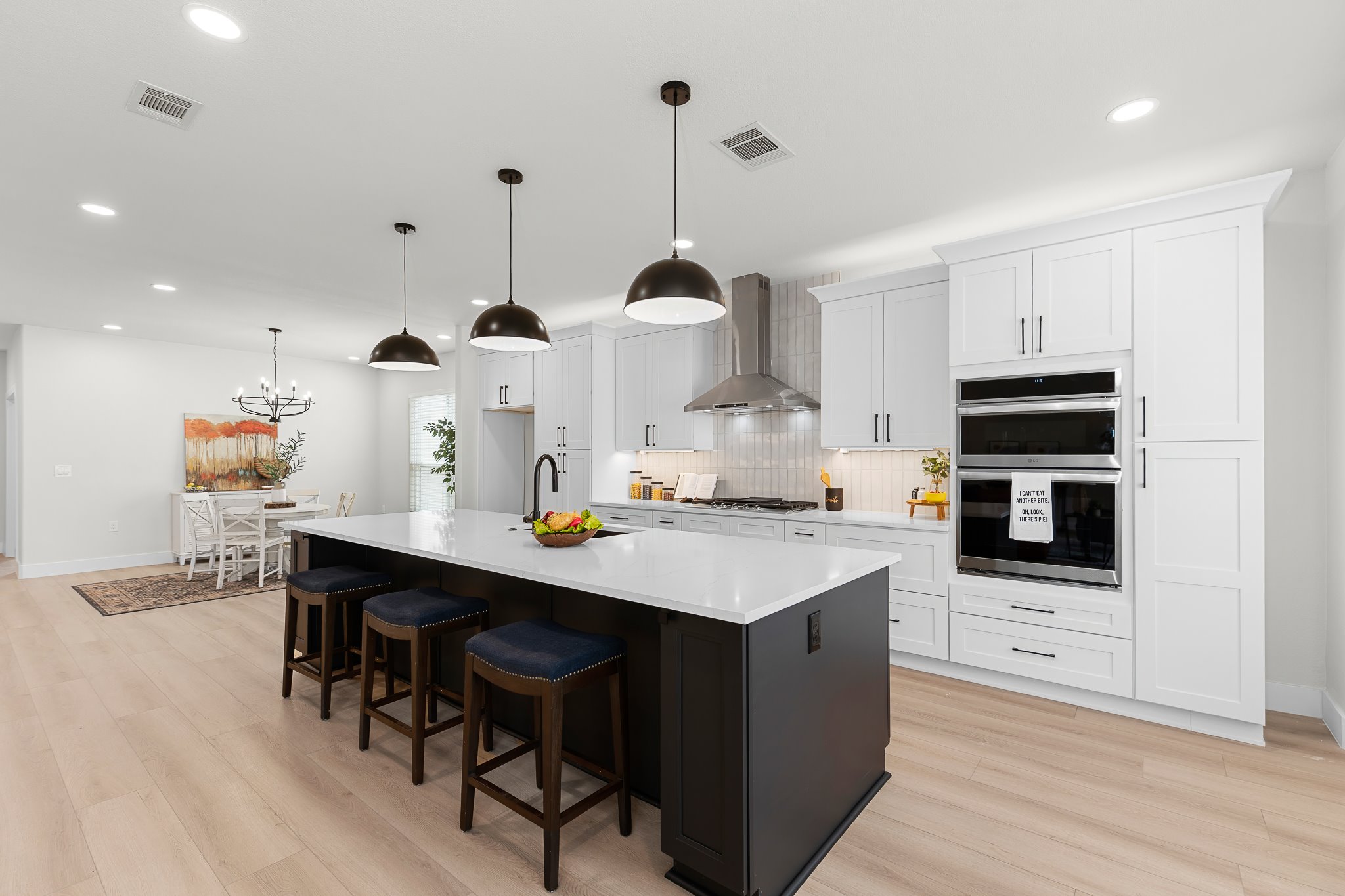 206 Armstrong Drive Georgetown, TX 78633 - Photo 22 of 39 a kitchen with stainless steel appliances a stove a sink island and a refrigerator with wooden floor