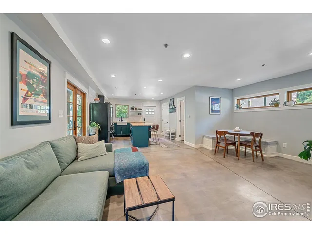 a living room with furniture and a dining table with wooden floor