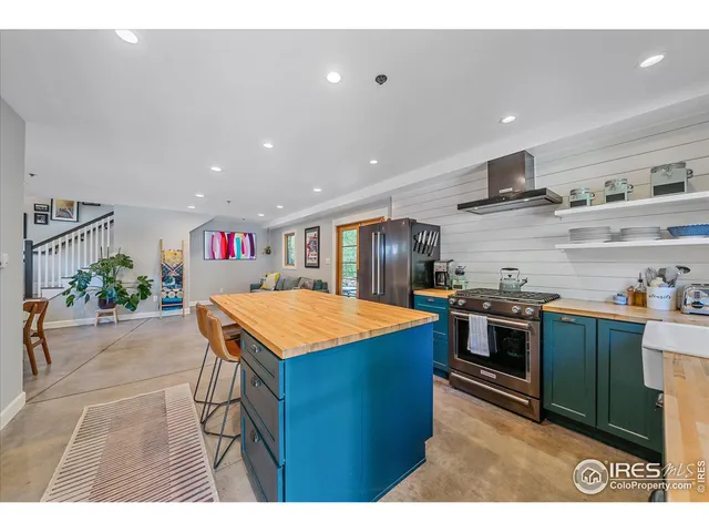 a kitchen with stainless steel appliances kitchen island granite countertop a table and chairs in it