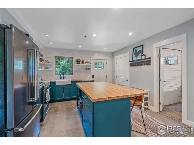 a kitchen with stainless steel appliances kitchen island a refrigerator sink and cabinets
