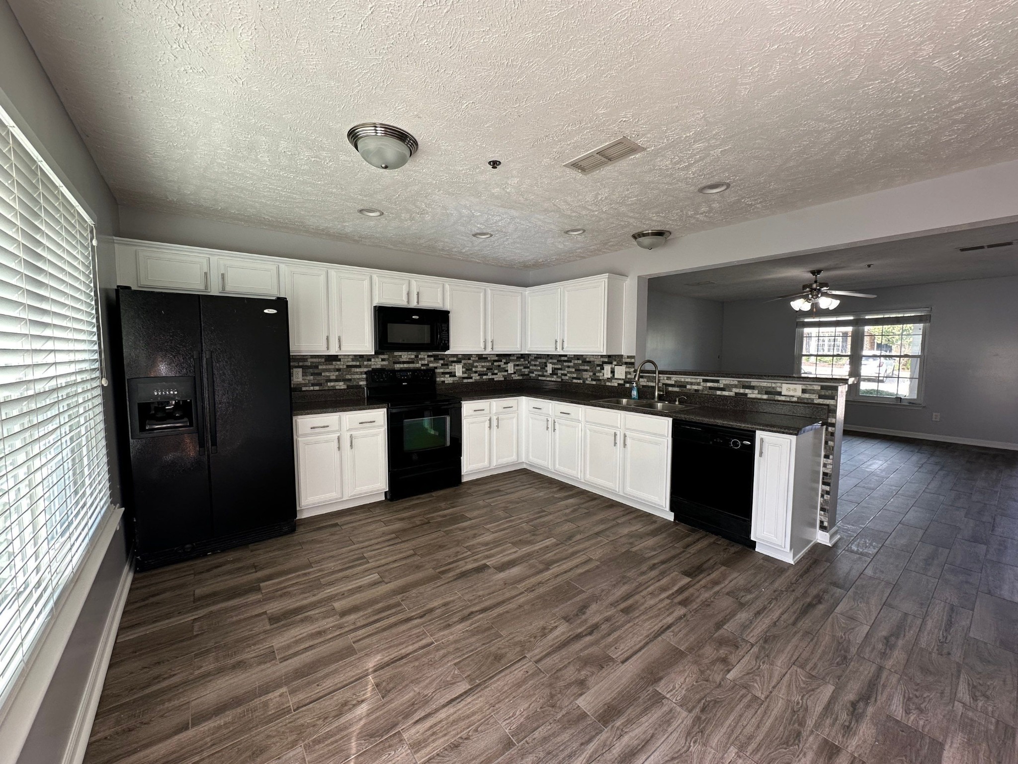 4020 Pavati Trace Spring Hill, TN 37174 - Photo 3 of 19 a large kitchen with stainless steel appliances granite countertop a stove top oven a sink and dishwasher with wooden floor