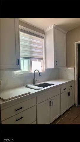 a kitchen with sink and mirror