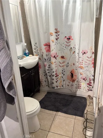 a bathroom with a toilet sink and curtain