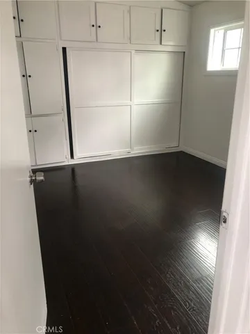 an empty room with wooden floor and white walls