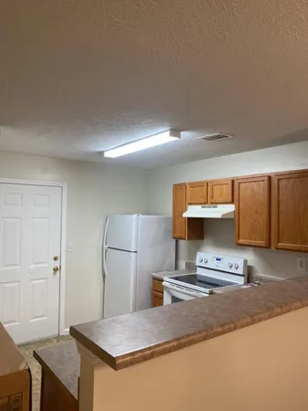 a kitchen with stainless steel appliances granite countertop a sink refrigerator and cabinets