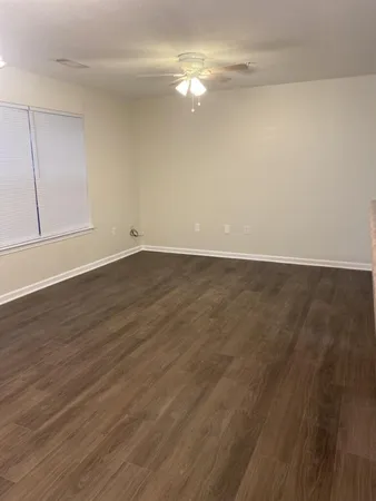 a view of an empty room with wooden floor