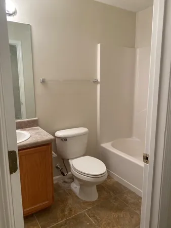 a white toilet sitting next to a bath tub