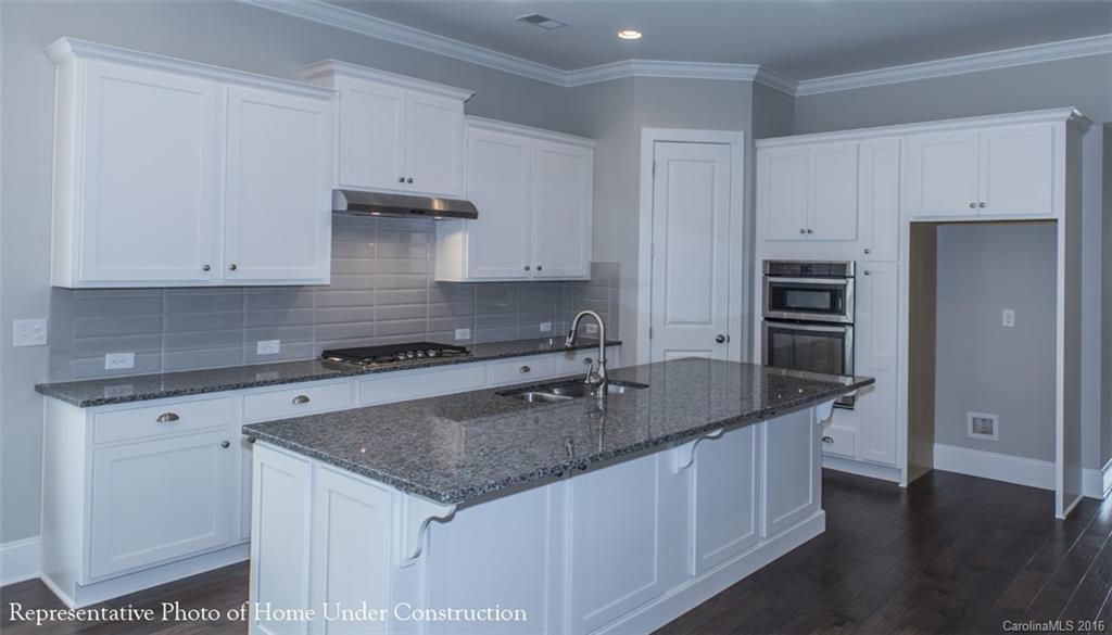 5219 Meadowcroft Way, Unit 149 Fort Mill, SC 29708 - Photo 3 of 7 a kitchen with stainless steel appliances granite countertop a sink stove and refrigerator