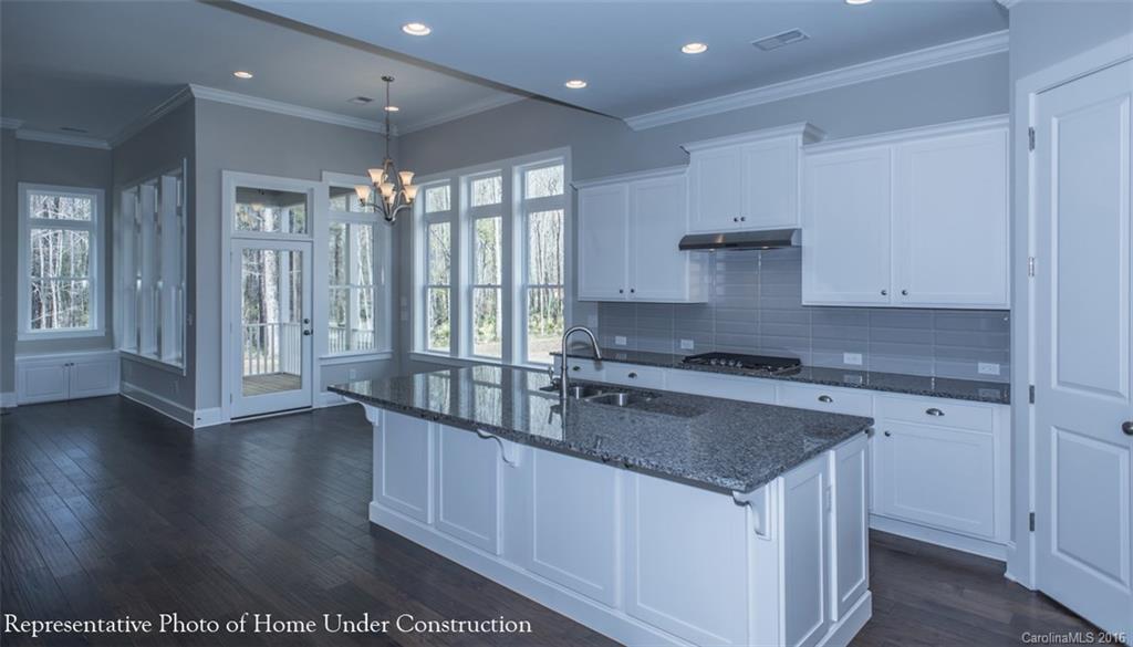 5219 Meadowcroft Way, Unit 149 Fort Mill, SC 29708 - Photo 4 of 7 a kitchen with stainless steel appliances granite countertop a sink a stove and a wooden floors