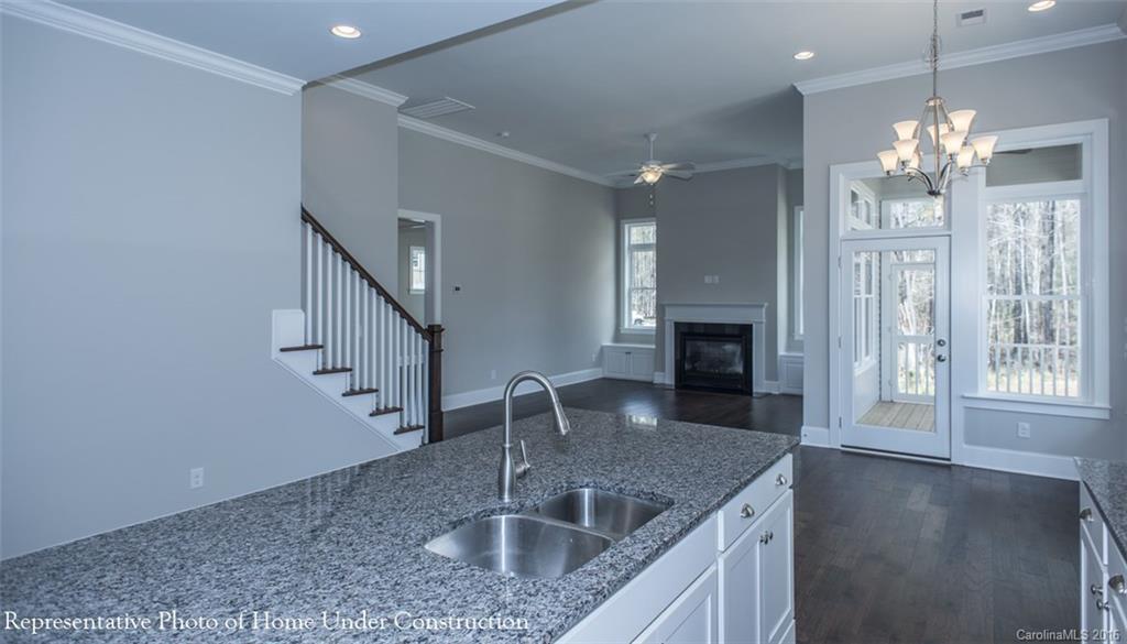 5219 Meadowcroft Way, Unit 149 Fort Mill, SC 29708 - Photo 5 of 7 a kitchen with stainless steel appliances granite countertop a sink dishwasher and a fireplace with wooden floor