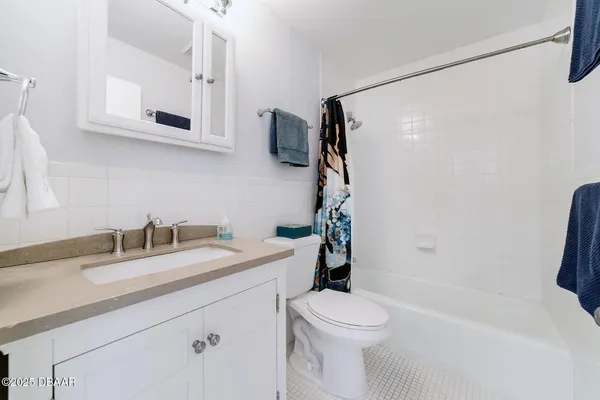 a bathroom with a granite countertop sink a toilet and shower