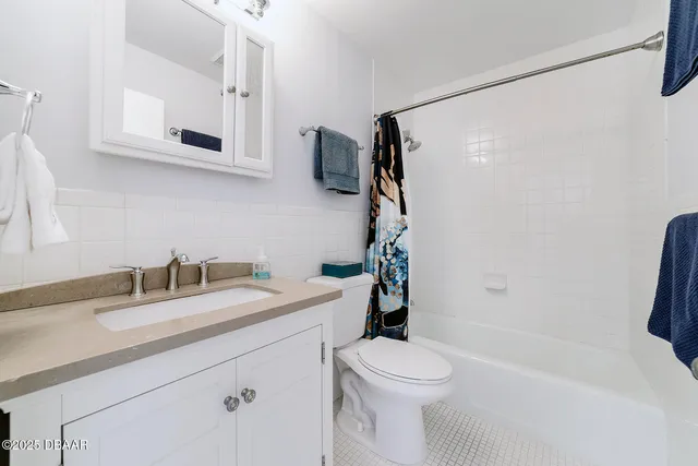 a bathroom with a granite countertop sink a toilet and shower