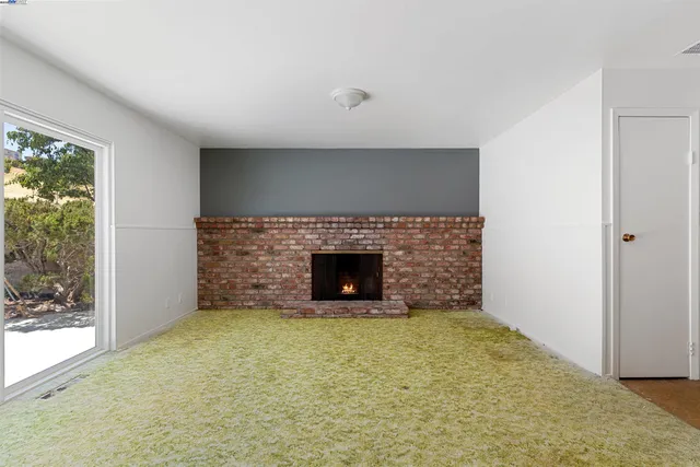 a view of an empty room with a fireplace