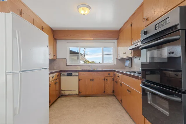 a kitchen with stainless steel appliances granite countertop a stove a sink and a refrigerator