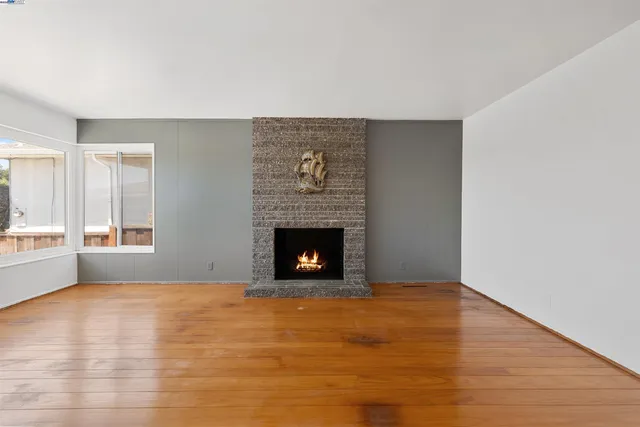 a view of an empty room with window and fire place