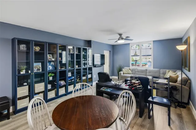 a living room with furniture and floor to ceiling window and potted plants