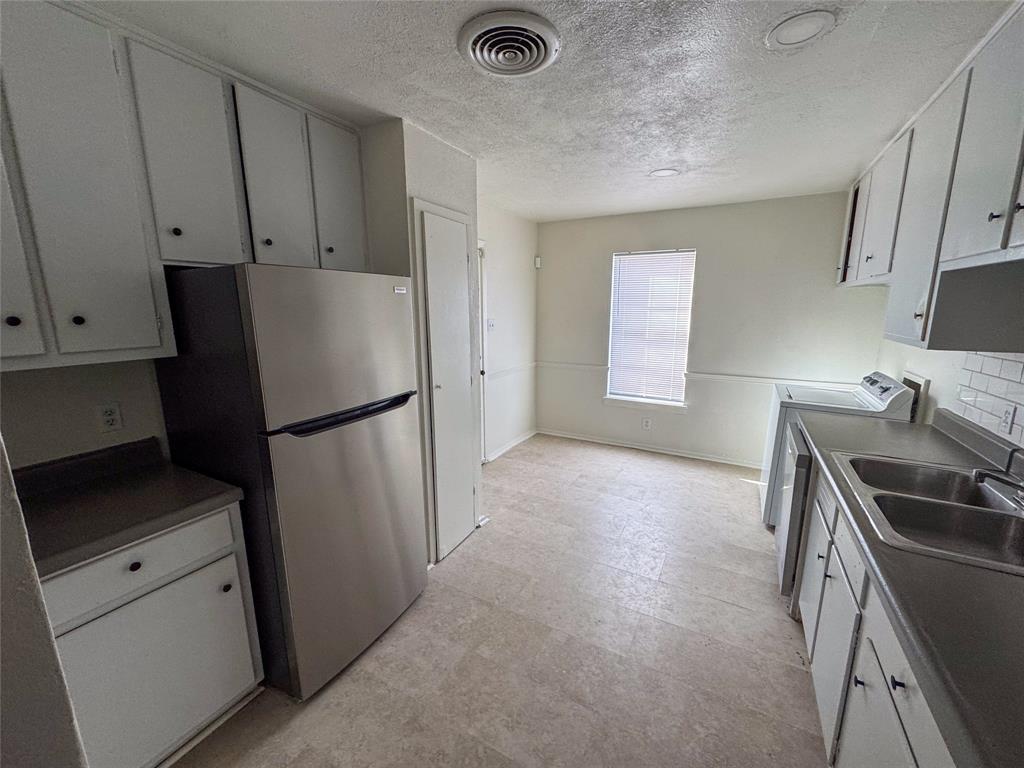 60 Pershing Drive, Unit A Denison, TX 75020 - Photo 4 of 11 a kitchen with a refrigerator and a stove top oven