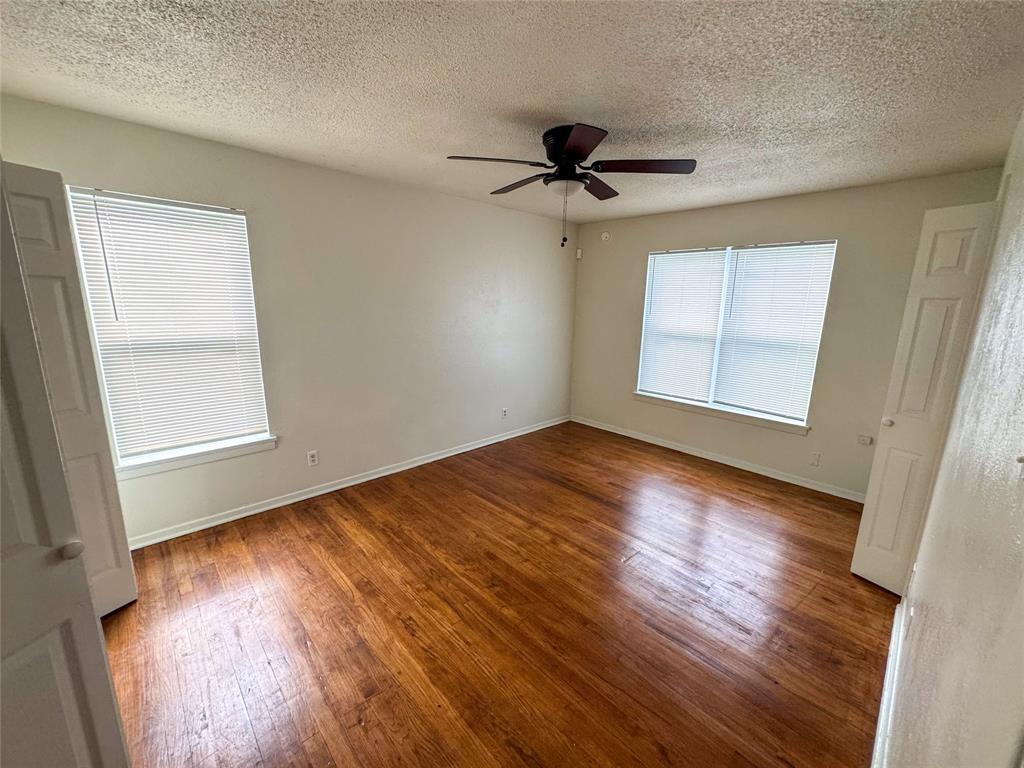 60 Pershing Drive, Unit A Denison, TX 75020 - Photo 7 of 11 a view of empty room with wooden floor and fan