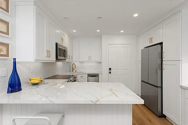 a kitchen with a refrigerator a microwave a sink and cabinets