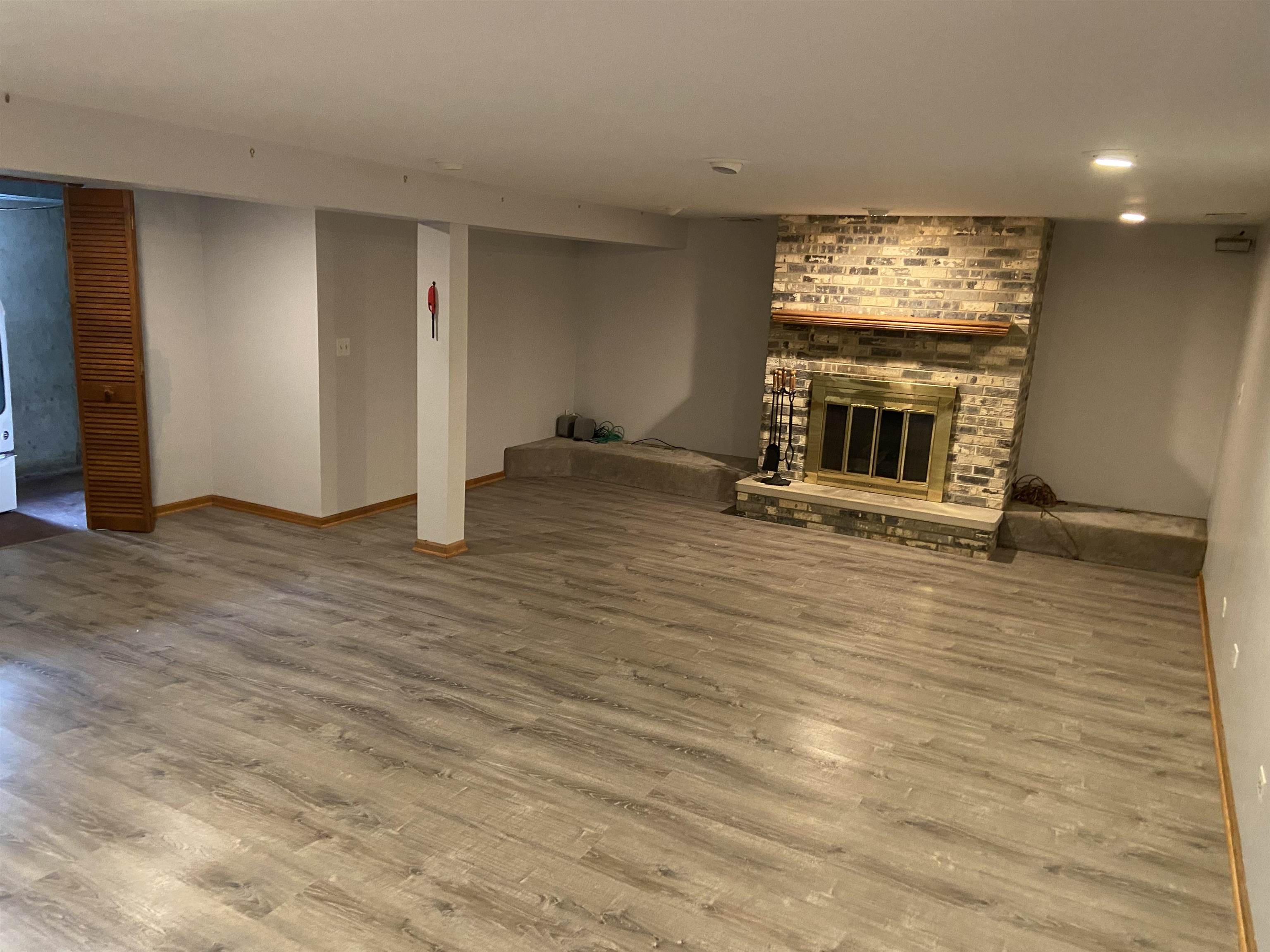 645 Sable Avenue Addison, IL 60101 - Photo 30 of 33 an empty room with wooden floor fireplace and windows