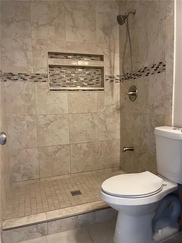 a bathroom with a toilet a sink and shower