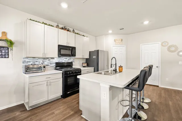 a kitchen with a stove a sink and a refrigerator