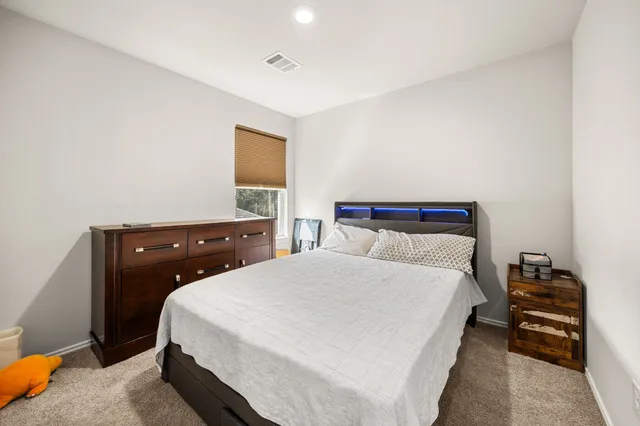 a bedroom with a bed and a night stand