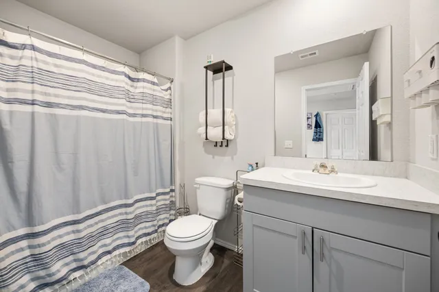 a bathroom with a sink a toilet and shower