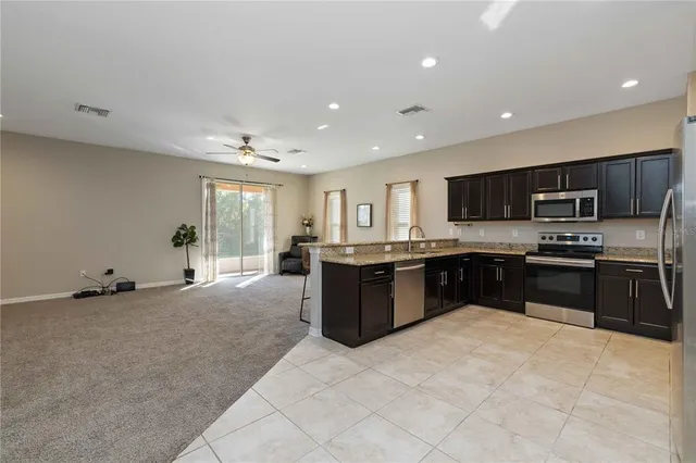 a large kitchen with stainless steel appliances granite countertop a large counter top and a stove