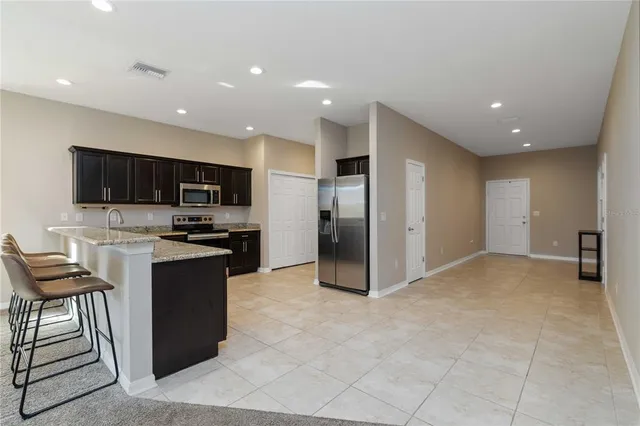 a kitchen with stainless steel appliances granite countertop a refrigerator and a stove top oven