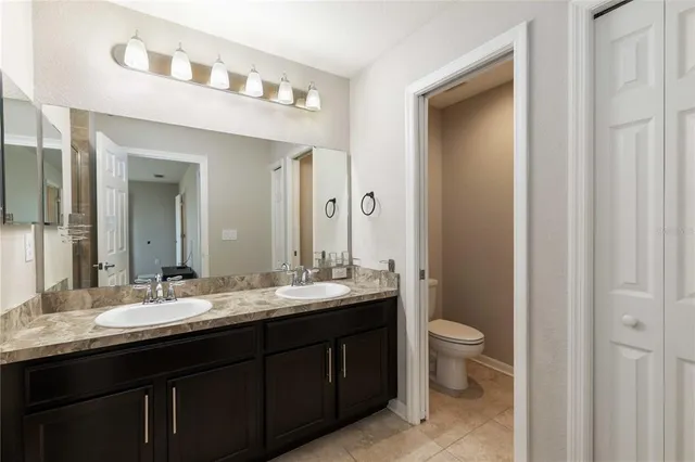 a bathroom with a double vanity sink toilet and a mirror