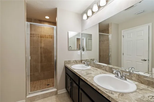 a bathroom with a granite countertop sink a mirror and shower
