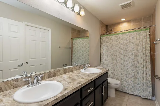 a bathroom with double sink and a mirror