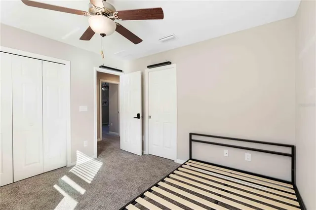 a bedroom with a bed and a ceiling fan