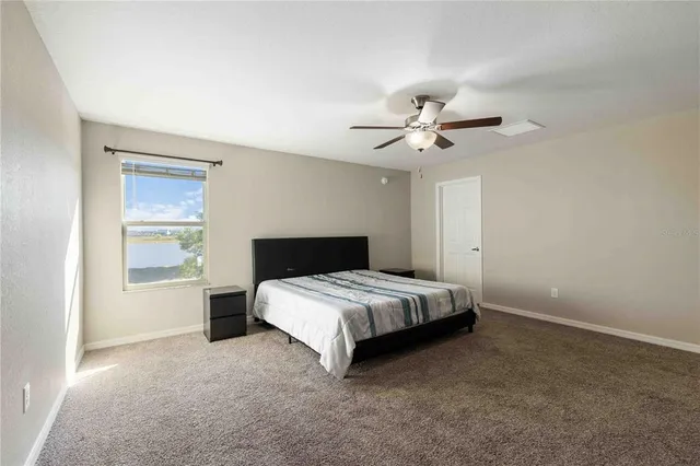 a spacious bedroom with a bed and a ceiling fan
