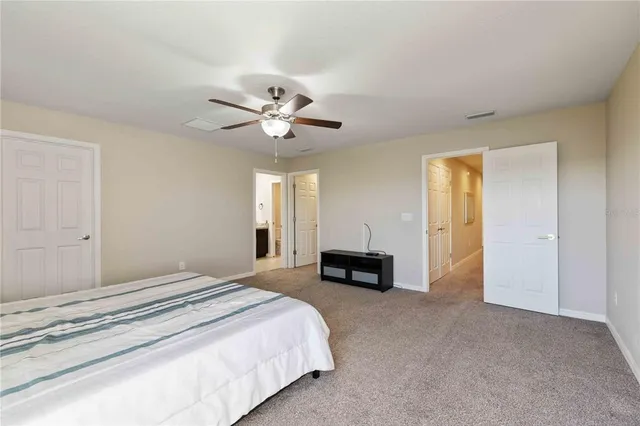 a spacious bedroom with a bed and a chandelier