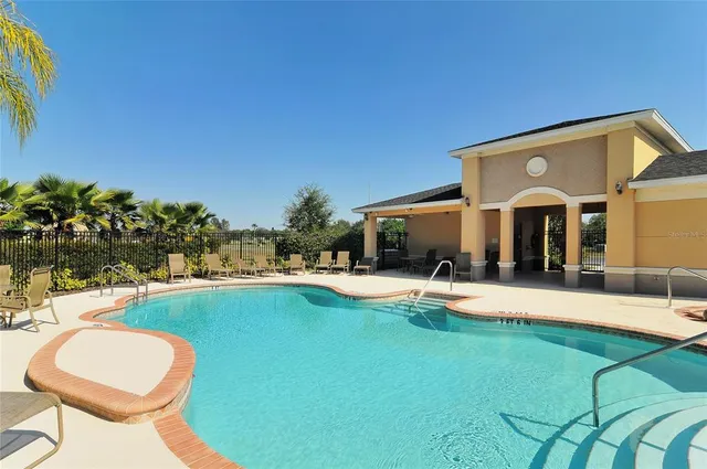 a view of a house with swimming pool and sitting area