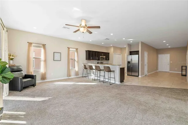 a view of a livingroom with furniture a ceiling fan and window